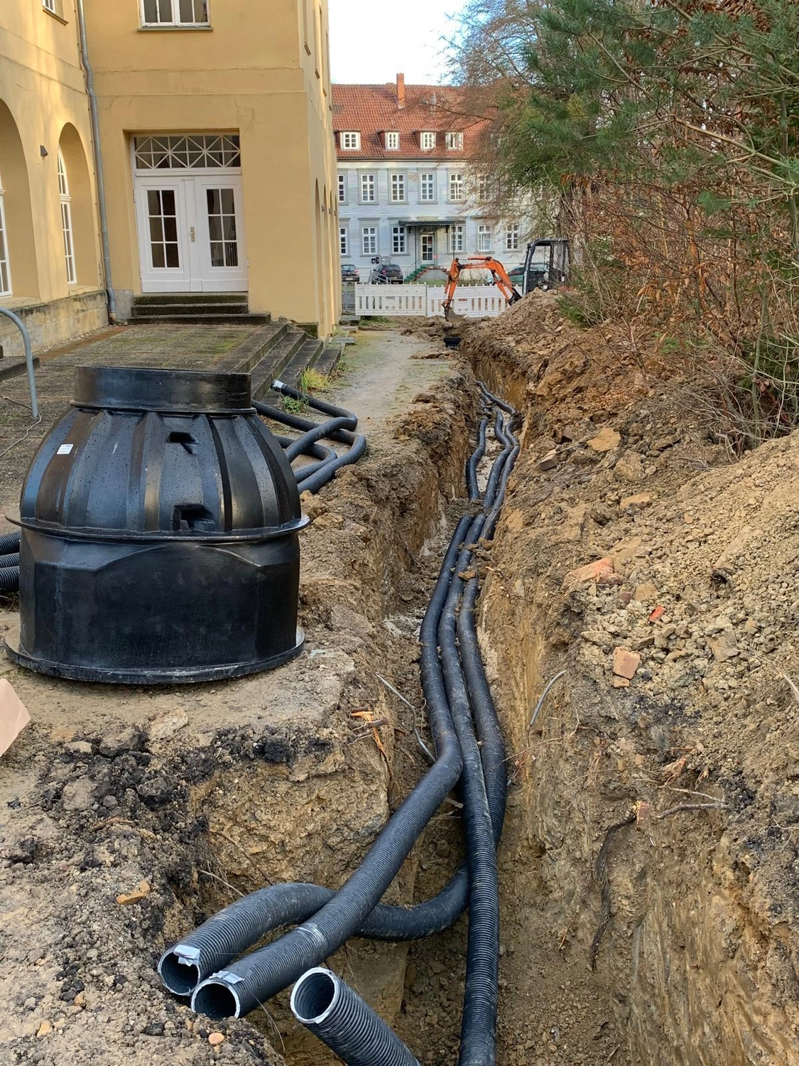 Stahlke – Tief- und Landschaftsbau – Auf dieser Baustelle werden flexible schwarze Wellrohre für Erdwärmepumpen oder Gebäudeinfrastruktur verlegt.